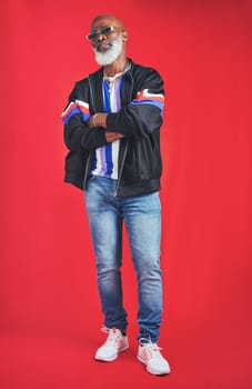 Your style is what makes you unique. Studio shot of a senior man wearing retro attire while posing against a red background.