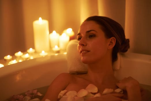 Soothed by the ambiance and a hot bath. Cropped shot of a gorgeous woman relaxing in a candle lit bath.