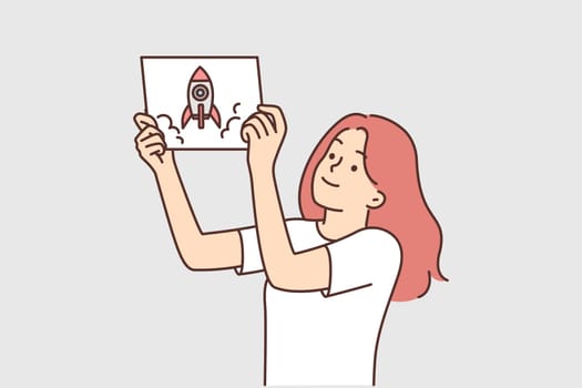 Girl demonstrates drawing of spaceship or rocket taking off and dreams of becoming woman astronaut
