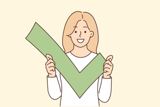Woman holds green check mark for sign approval and successful account verification in social network