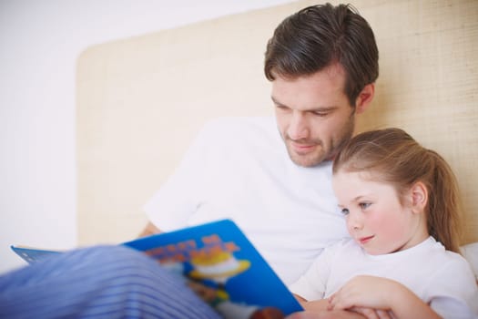 Fairytales for Little Girls. A devoted father reading his young daughter a bedtime story.
