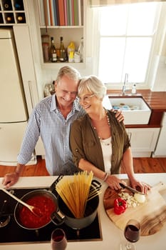 Affection, smile or happy old couple kitchen cooking with love or healthy food for dinner together at home. Embrace or above of senior woman helping or hugging an elderly husband in meal preparation