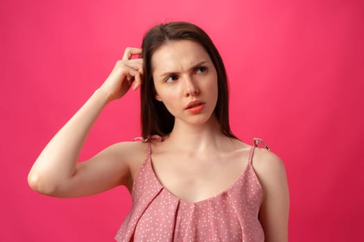 Portrait of young woman thinking and wonder against pink background