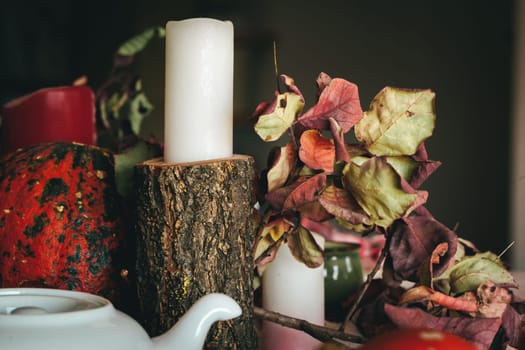 Autumn decor with pumpkin, candles and tableware