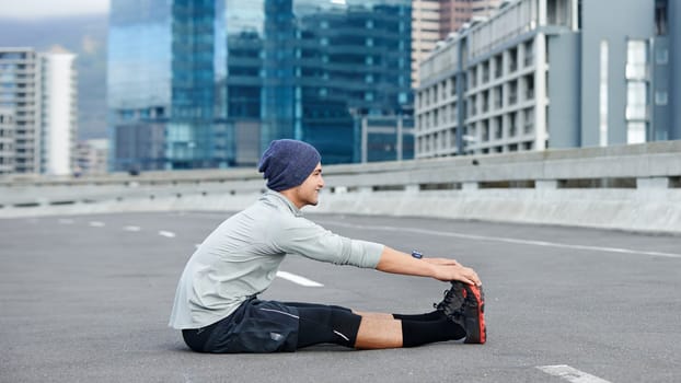 Readying for the run. a young male jogger stretching on an empty street before a run.