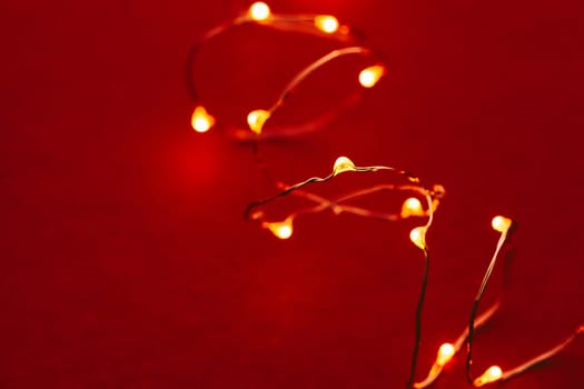 Red background with illuminated lights of garland