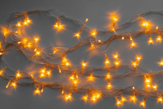 Glowing golden electric garland on a gray background