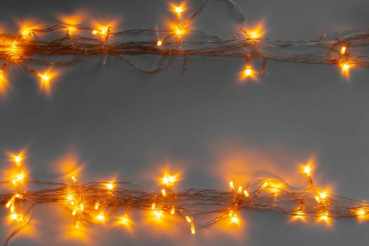 Glowing golden electric garland on a gray background