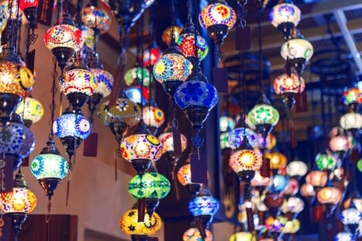 Middle Eastern lamps of different colors hanging in bazaar