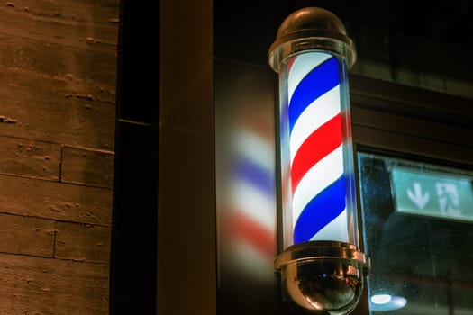 Barbershop pole sign attached to a wall of building