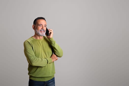 Smiling handsome old european man calls by smartphone, talking