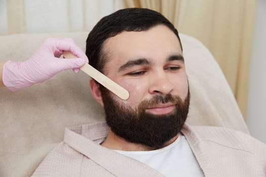Man getting ready for a laser hair removal on his face at cosmetologist