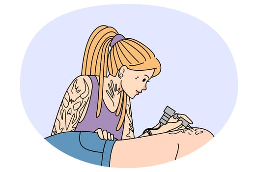 Woman artist draw ink tattoo on client body