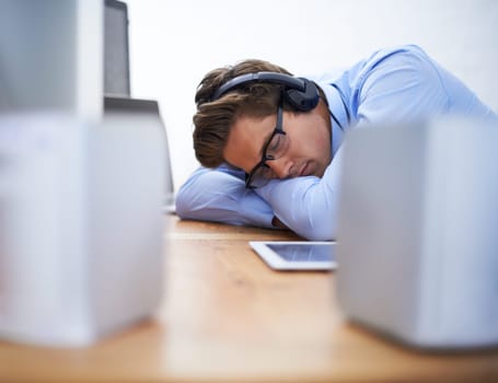 Office desk, sleep and business man tired after working on project, software system or coding tech, script or programming. Programmer burnout, developer fatigue and sleeping person listening to music