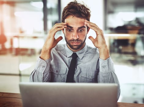 Businessman, laptop and headache in stress, anxiety or burnout in shock from debt at office desk. Frustrated man person or employee with bad head pain or overworked in financial crisis at workplace