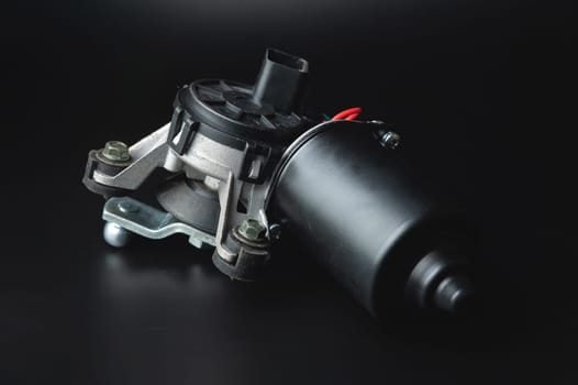 Wiper motor on a black background. Auto parts catalog.