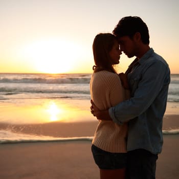 Passion at sunset. a loving young couple embracing on the beach at sunset.