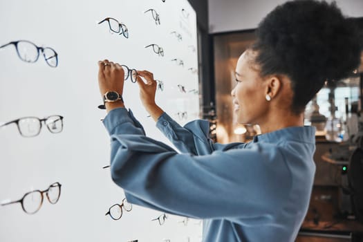 Optometry, healthcare and woman choosing a frame for her prescription lenses at optical store. Medical, ophthalmology and African female patient shopping for new glasses or spectacles at optic clinic