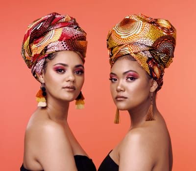 African fashion, beauty and portrait of women on orange background with cosmetics, makeup and accessories. Glamour, studio and face of female people with exotic jewelry, traditional style and luxury