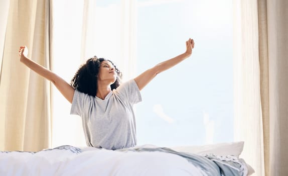 Black woman, morning stretching and wake up in home bedroom after sleeping or resting. Relax, peace and comfort of young female stretch after sleep feeling fresh, awake and well rested in house.