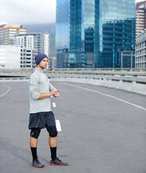 Best time yet. a young jogger checking the time while out for a run in the city.