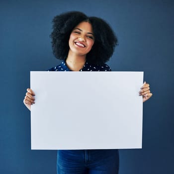 News, mockup and portrait of a woman with a poster isolated on a blue background in studio. Smile, showing and young corporate copywriter with a blank board for branding, design and information space