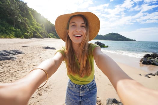 Brazilian girl takes self portrait on empty tropical paradise beach in Brazil on summer