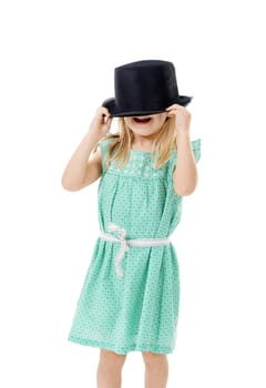 Bet you cant see me. Studio shot of a cute little girl wearing a funky hat against a white background.