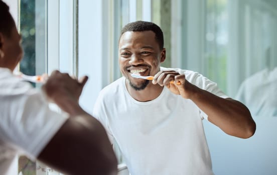 Morning, happy and black man brushing teeth in bathroom for health, hygiene and clean smile. Self care, cleaning and oral hygiene for healthy teeth of person smiling with confidence in home