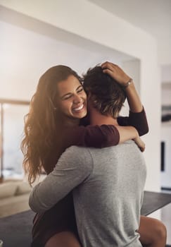 Happy young couple hugging in home for love, romance and caring bond together with excited partner. Woman, man and hug of lovers in relationship, dating and smile for happiness, care and loyalty.