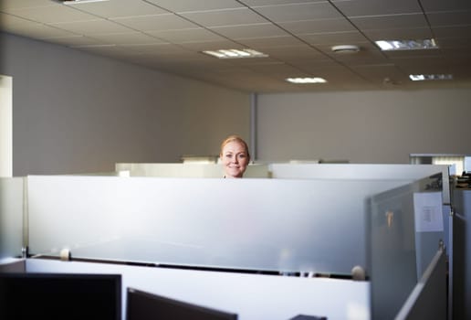 Work is what you make it. Portrait of an attractive young woman standing in her office cubicle.