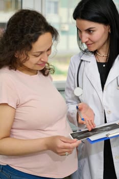 Pregnant woman and female doctor consulting about the ultrasound scan of baby. Obstetrics and gynecology. Pregnancy