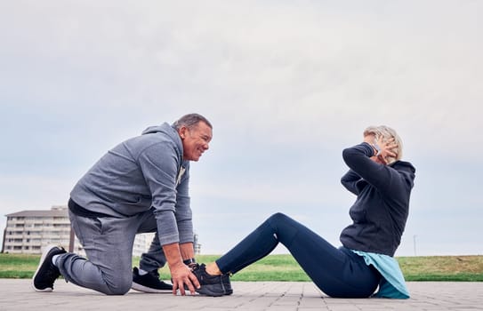 Fitness, health and sit ups with a senior couple training outdoor together for an active lifestyle of training. Workout, exercise or core with a mature man and woman outside on the promenade.