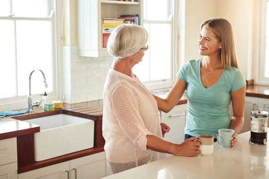 Mother, coffee or happy woman speaking in kitchen in family home bonding or enjoying quality time together. Affection, retirement or daughter talking, relaxing or drinking tea with senior parent