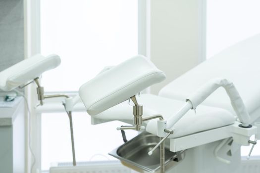 Empty white gynecological chair in modern medical center