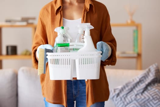 Cleaning, hygiene and detergent with a woman holding a basket of products as a cleaner in a home. Bacteria, container and spray bottle with a female housekeeper ready to clean with disinfectant