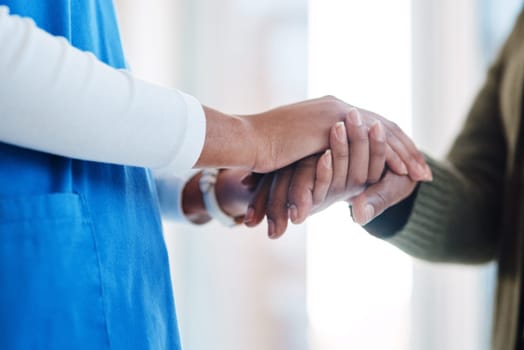 Woman, holding hands or consulting a nurse for support or empathy for healthcare service of cancer therapy. Closeup, psychology clinic or sick patient in counseling with a caregiver in consultation