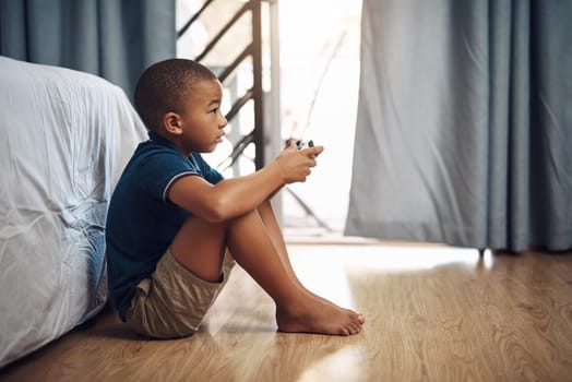Video games are super fun. a young boy playing video games at home.