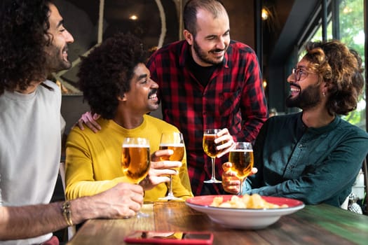 Group of happy male friends having beer in a pub. Leisure time and friendship concepts.