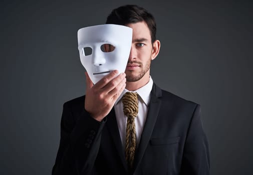 Two faces, holding mask and businessman portrait in a studio with serious face with secret and fraud. Worker or corporate criminal with rope tie showing identity theft or liar in business suit mockup