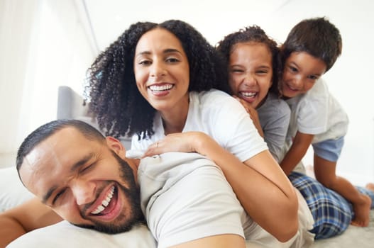 Happy family, selfie and portrait with children and parents relax, play and have fun in bed at home in the morning. Face, smile and kids waking up with mother and father for photo while bonding