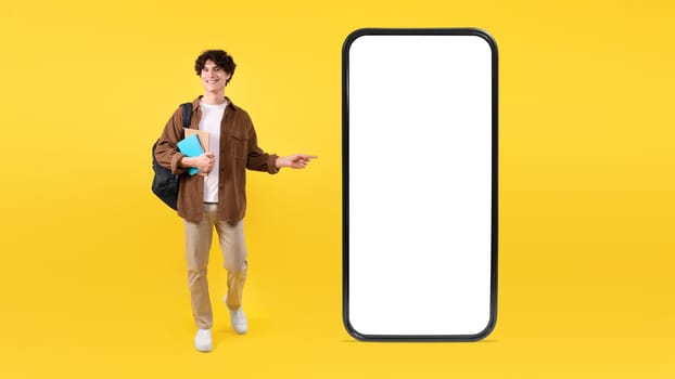 Guy Promoting New App On Large Smartphone Over Yellow Background