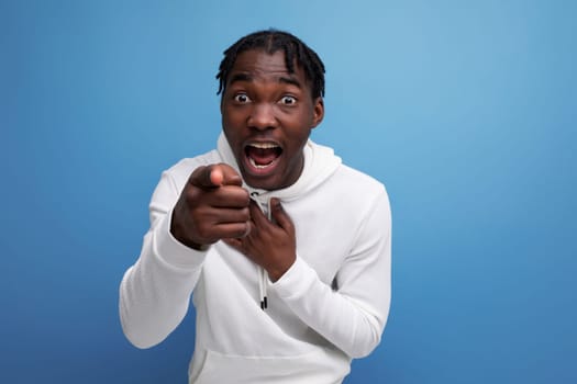 happy surprised american 20s man with dreadlocks on background with copy space