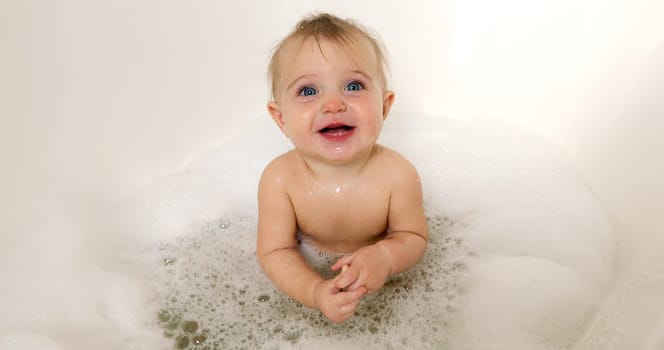 happy baby boy laughing in bath tub