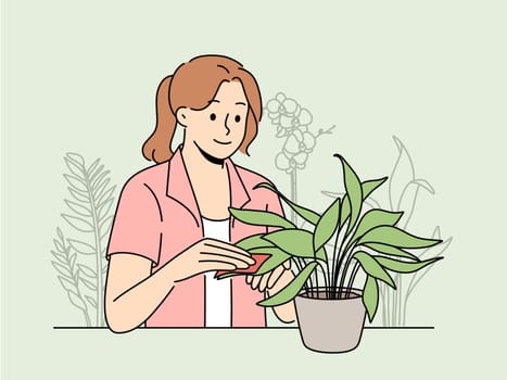 Happy woman clean leaves of houseplant