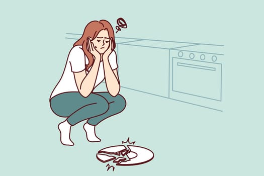 Sad woman broke plate in kitchen and is sad because of favorite saucer given by friends
