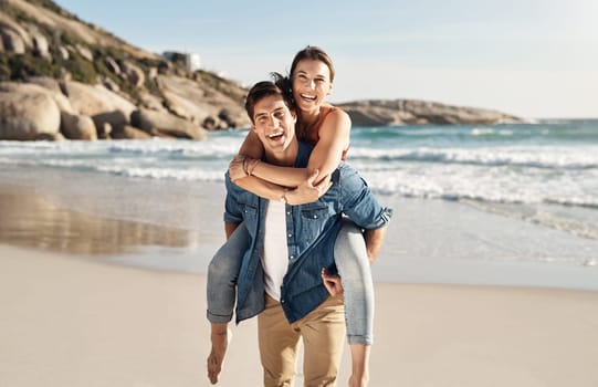 Couple, portrait and piggyback with smile at beach in summer sunshine for love, romance and bond for travel. Man, woman and happy with hug, ocean waves and trust in nature, outdoor and sea holiday