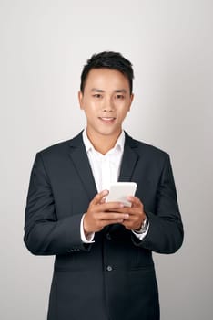 Handsome smiling businessman using cellphone over white