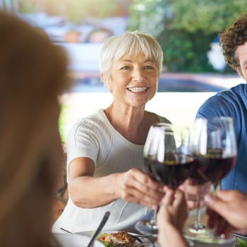 Senior woman, group and wine glass for toast at table for celebration, food or friends at lunch event. People, together and celebrate with alcohol, glasses or support at party, dinner and family home.