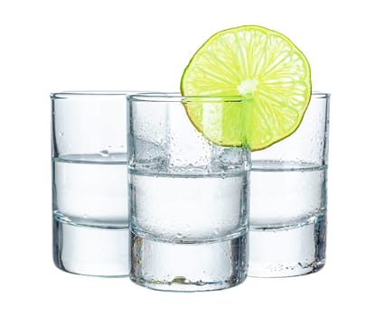 Three tequila shots with lime isolated on white background
